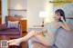 A woman sitting on a couch in a blue lingerie.