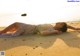 A woman laying on the sand on a beach.