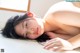 A woman laying on top of a bed next to a window.