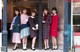 A group of young women standing in front of a building.