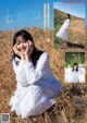 A woman in a white dress sitting in a field.